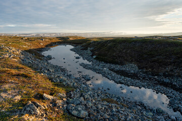Obraz premium A small pond in the rocky terrain up in the fells, Vardø, Varanger Peninsula