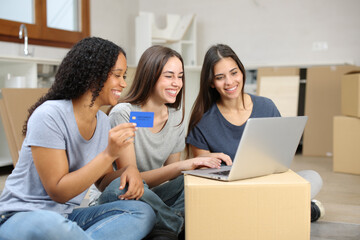 Three happy roommates moving home buying online