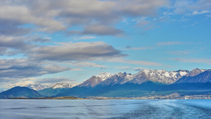 Ushuaia’s panoramic view, snow-capped mountains, calm sea, picturesque cityscape, nature’s splendor, serene waterscape, southernmost city charm