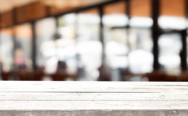 A rustic wooden table top with a blurred background of a cafe.