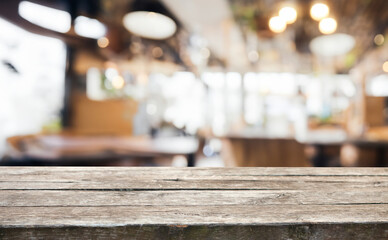 Rustic wooden table top with a blurred background of a cafe or restaurant.