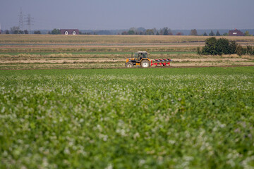 Agriculture machinery in action a tractor plows a field on a bright day