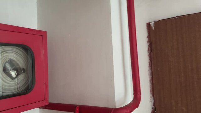 Panning shot showing Fire extinguisher cabinet mounted on the wall, Fire hose reel, extinguishers and fire hoses in the corridors