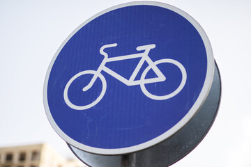 There is a blue sign displaying a white bicycle symbol on it