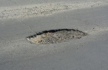 Road pit. Close up on asphalt road pothole need to repair.