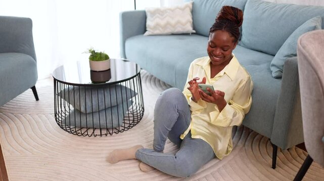 African American woman surfing the net and relaxing at her living rom