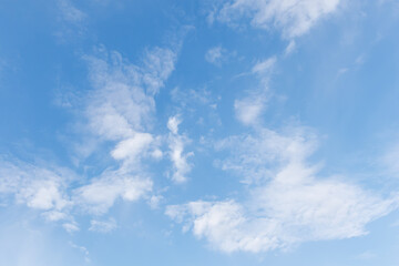 Calm blue sky with fluffy white clouds on a calm natural background. Soft fluffy clouds in the blue sky