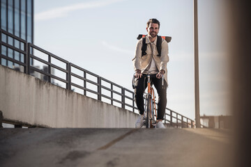 Man riding bicycle in front of sky on sunny day