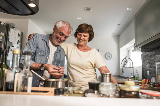 Happy couple cooking in kitchen at home