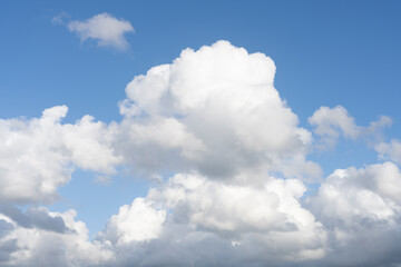Fluffy white clouds, against a bright blue sky, with little editing.