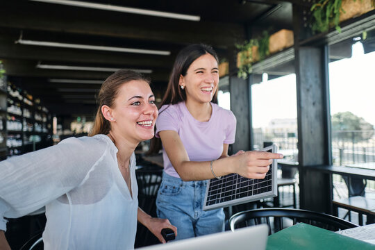 Two young women working together on sustainable resources project at coworking space