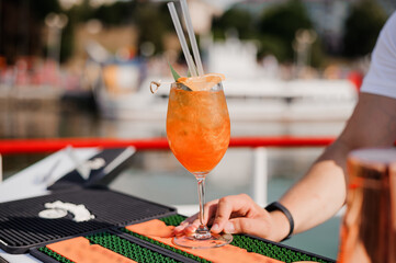 Refreshing Summer Cocktail with Citrus Garnish Served by Bartender on a Sunny Day by the Water