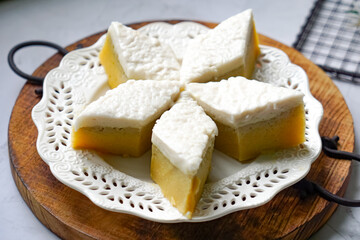 Kuih Talam Pisang, a steamed dessert made with banana and rice flour, featuring a soft, layered texture and sweet, creamy flavor.