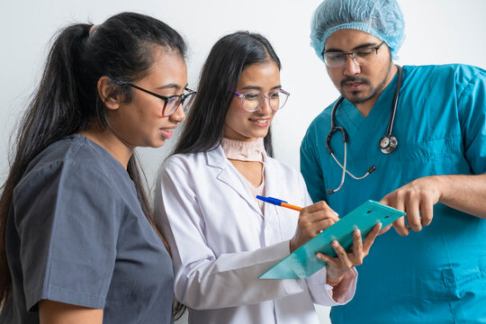 Young doctors discussing medical document against white background