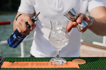 Skilled Bartender Mixing a Refreshing Cocktail in a Scenic Outdoor Setting