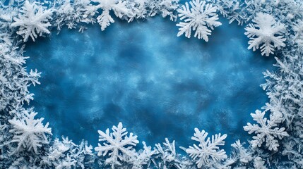 Close-up view of delicate, frost-covered snowflakes with intricate patterns, framed by soft, icy branches. The blurred blue background with falling snow creates a serene, wintery atmosphere.