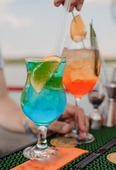 Refreshing Colorful Cocktails Served on a Summer Day by the Water with Bright Citrus Garnishes