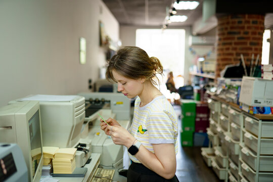 Woman standing near computer in a printing shop