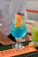 Refreshing Tropical Mocktail in a Colorful Glass with Citrus Garnish by the Seaside