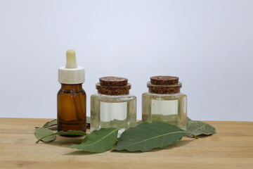 daphne leaves and essential oil in bottles on white background