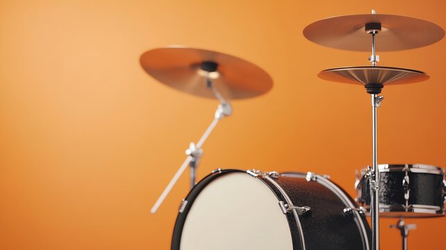 Close-up of a drum set with shimmering cymbals against a vibrant orange background, perfect for music-themed visuals.