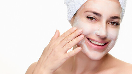 Woman enjoying skincare routine with facial mask and towel