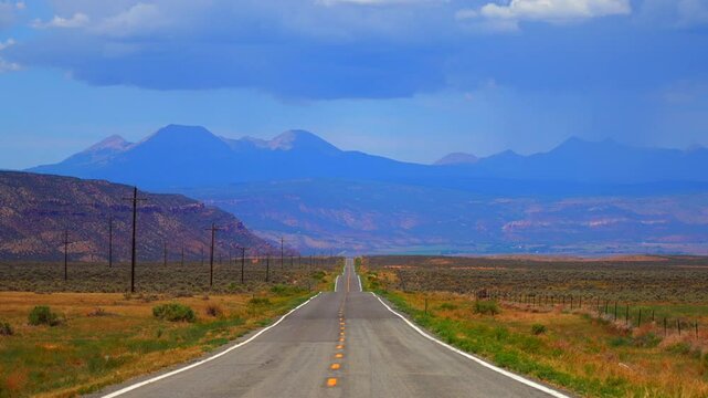 Colorado Utah Border slow zoom in motion highway 90 road Moab Spanish Valley La Sal Mountain Rocky Mountains road Telluride Montrose county summer dry Redvale Norwood rain thunderstorm clouds sunny