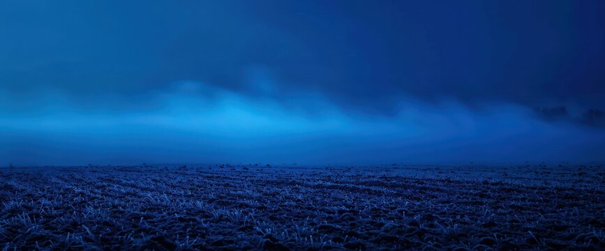 Indigo vapor cloaking an empty night field, mysterious and foreboding."
