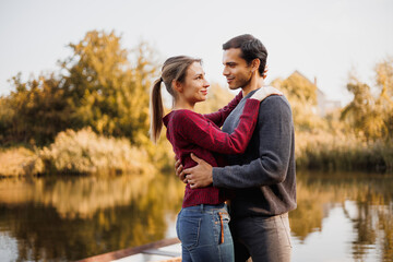 Romantic couple hugging near lake on background in autumn