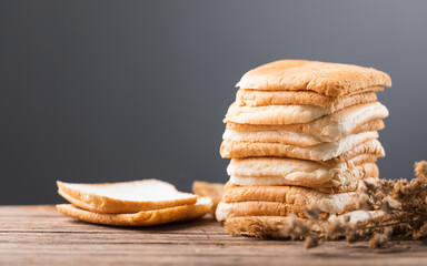 Slices of bread stacked on a gray wooden table against a dark gray background. The image symbolizes the connection between food, nutrition, and maintaining good health.
