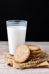 Healthy oatmeal cookies and milks on wooden table.
