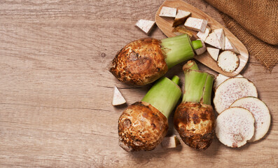 top view flat lay group of fresh taro and slice on wood table background with copy space