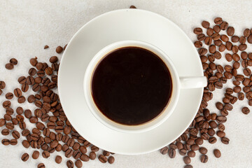 White cup of fresh brewed black coffee decorated with coffee beans