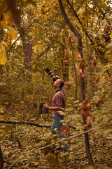 Naklejka premium Man using binoculars and camera for bird and animal watching in nature.