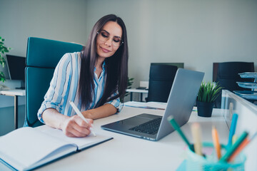 Photo of professional lovely lady write notebook work netbook wear striped formalwear coworking successful businesswoman nice light office