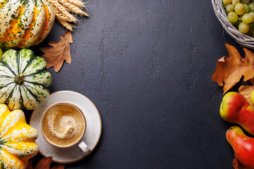 Autumn-themed food arrangement with pumpkins, pears, grapes, and autumn leaves