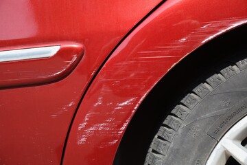 Scratched paint on red car