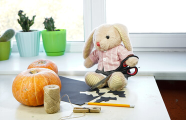 Toy bunny prepares decorations for Halloween
