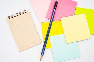 Blank paper note on blank colorful sticky note and pencil isolated on white background. Copy space.