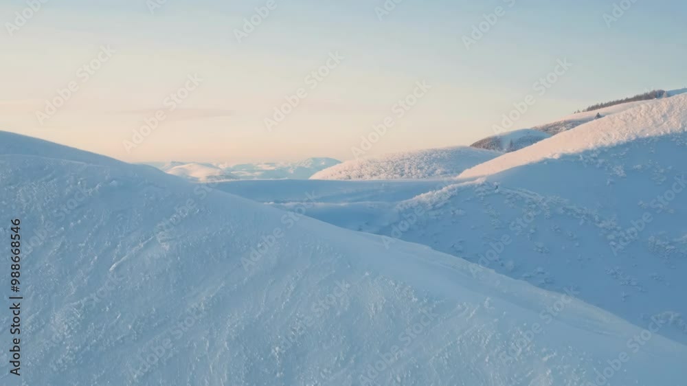 Poster smooth, sparkling snow blankets two hills, untouched and sparkling in the winter sun, creating a ser