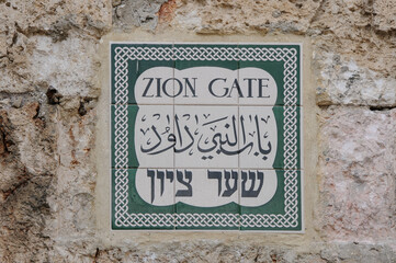 A ceramic tile street sign in Hebrew, Arabic and English in the Old City of Jerusalem marking the Zion Gate entrance.