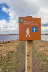Sign for the one way Knuppelpad walking path over the lake in Roegwold, Netherlands