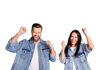 Portrait of cheerful people screaming yeah raising their fists closing eyes wearing denim jeans isolated over blue background