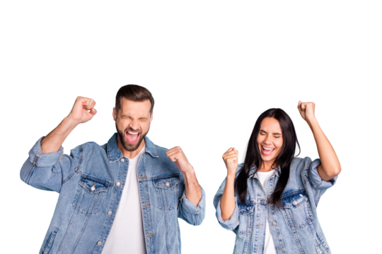 Portrait of cheerful people screaming yeah raising their fists closing eyes wearing denim jeans isolated over blue background