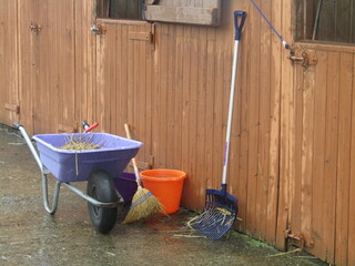 A Wheelbarrow and Tools for Mucking Out a Horse Stable.