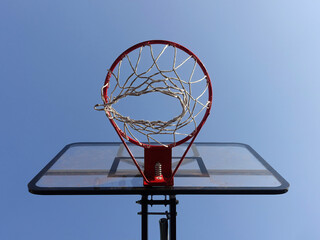 Basketball hoop with net on an outdoor court with sky background