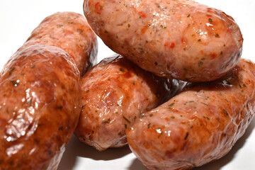 The picture shows delicious thick sausages on a white background.