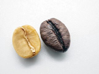 Close-up of green coffee bean seed and Coffee bean dark roasted seed on white background