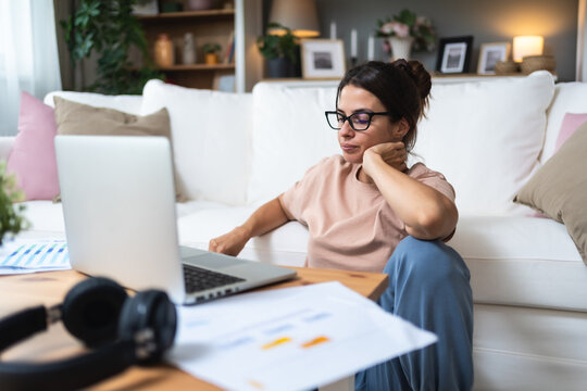 Young tired frustrated and overworked freelance woman working at home, feeling tiredness and exhaustion from work. Professional finance and economy female expert exhausted after video call.