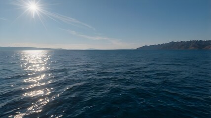 Obraz premium Blue ocean water beneath a clear blue sky, showcasing crystal-clear water on a beautiful summer day with soft waves